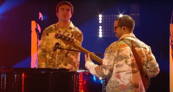 two men in brocade jackets playing piano and guitar